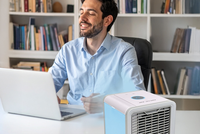 Mann sitzt im Büro mit ArticAir und hat eine angenehme Kühle