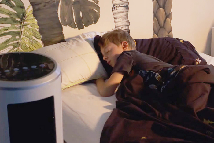 Kind schläft neben dem mobilen Luftkühlgerät.