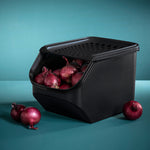 Rote Zwiebeln sind in einem schwarzen Tupperware OnionSmart Behälter aufbewahrt.
