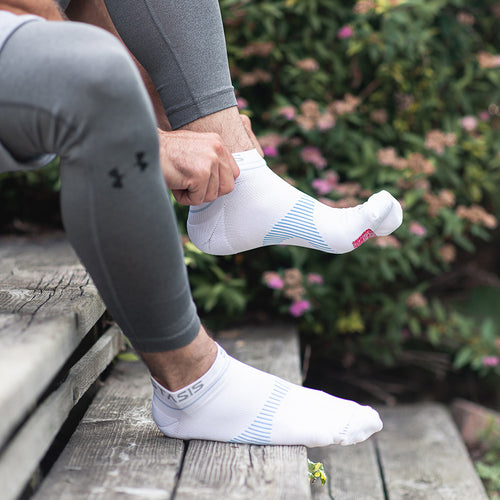 Neuro Socks Athletic – weiße Sportsocken werden vor dem Training im Freien angezogen.