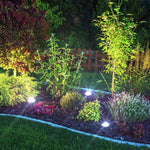Disk Lights Stone sorgen für dekorative Beleuchtung zwischen Sträuchern und Beeten im Garten.