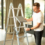 Ein Mann montiert eine Trittfläche an der Hammersmith SuperLadder in Stehleiter-Konfiguration.