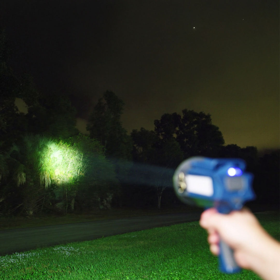 Hand hält starke LED-Lampe und leuchtet Bäume bei Nacht aus