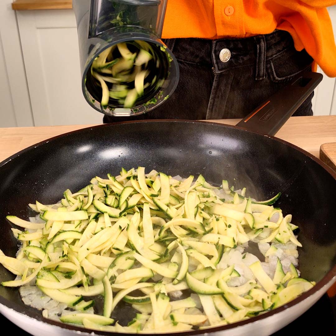 Geschnittene Zucchini werden in Pfanne gegeben