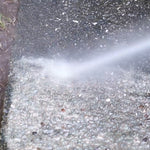 Hammersmith HydroBlast entfernt kraftvoll Schmutz von einer rauen Steinoberfläche mit Hochdruck.