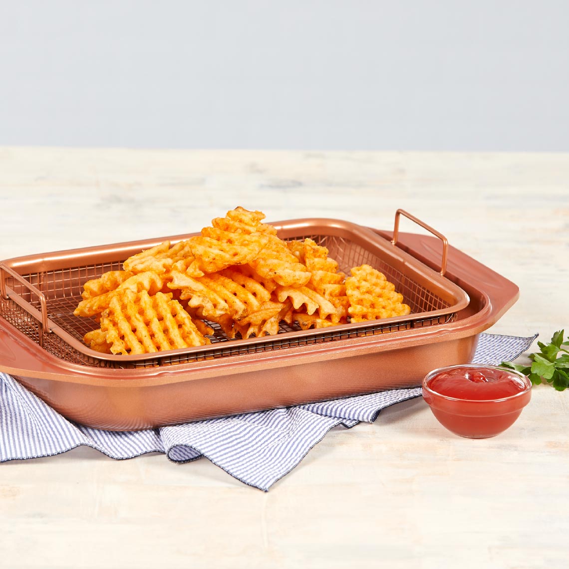 Livington Copperline WonderCooker – Gittereinsatz mit Waffel-Pommes, serviert mit Ketchup.