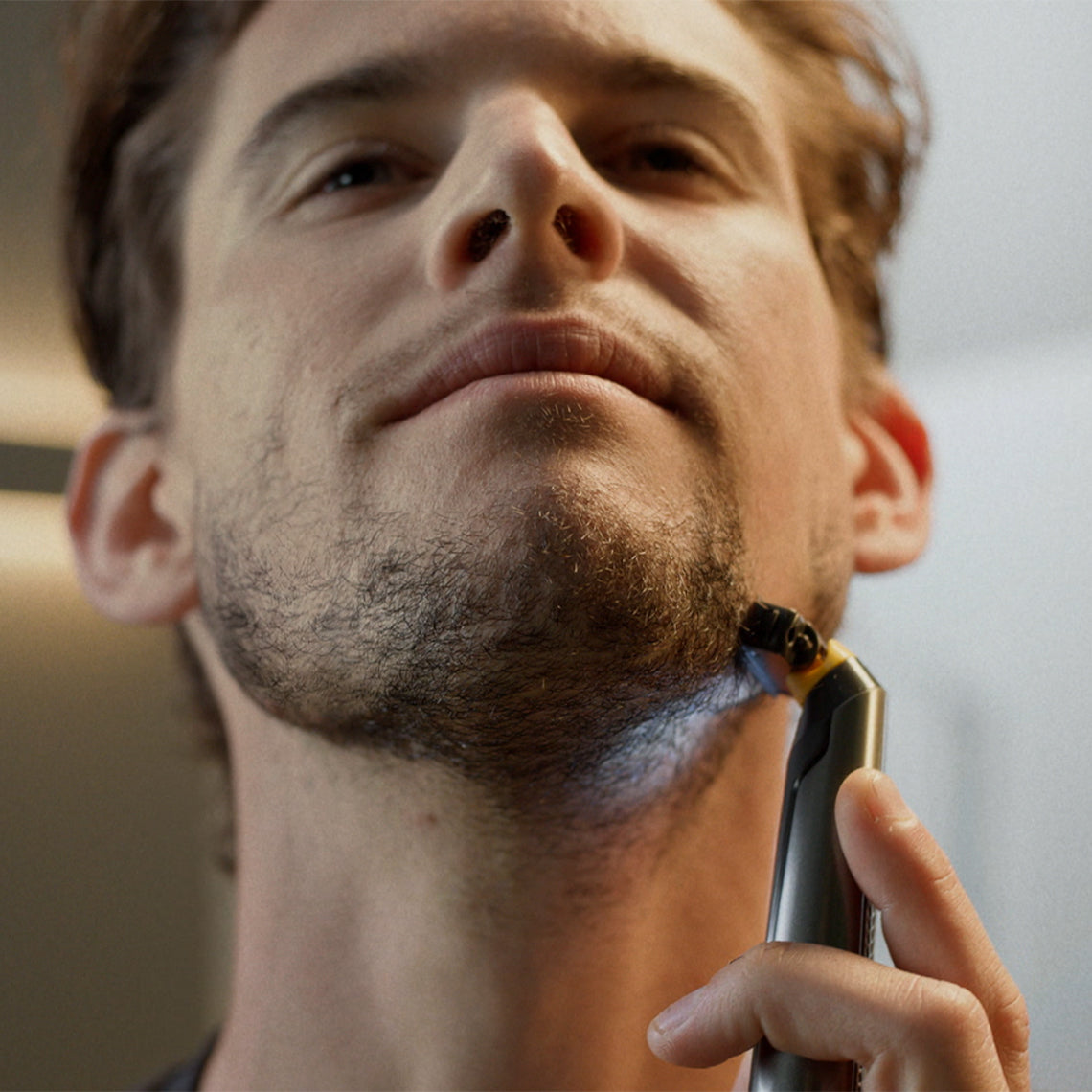 Ein Mann formt seinen Bart unter dem Kinn mit dem MicroTouch Titanium Solo mit LED-Licht.