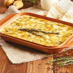 Livington Copperline WonderCooker – Kartoffelgratin mit Rosmarin in kupferfarbener Auflaufform auf Holztisch.