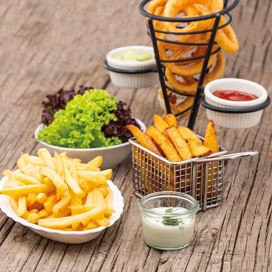 Serviervorschlag mit Pommes, Wedges, Onion Rings, Salat und Dips – ideal als Beilage oder Snack.