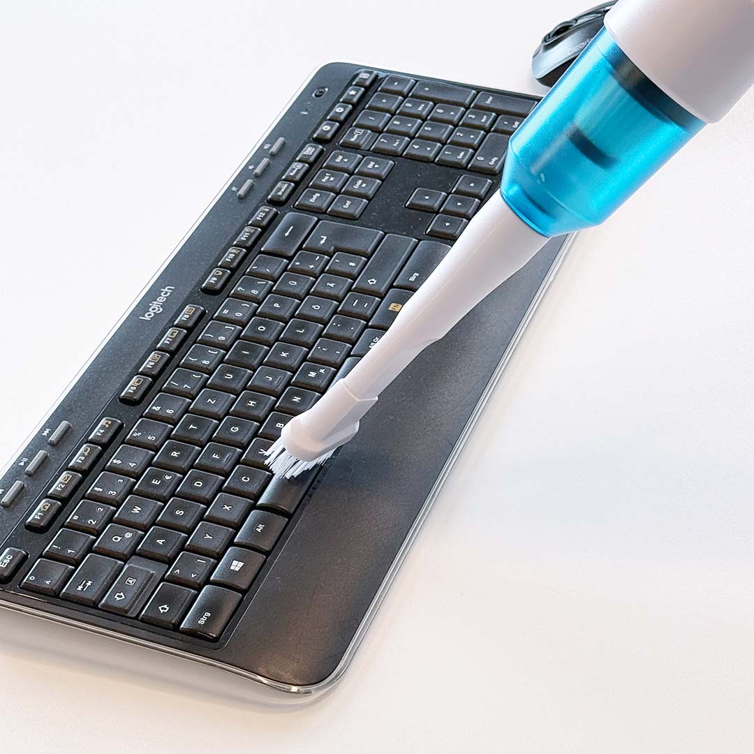Akkustaubsauger reinigt Tastatur