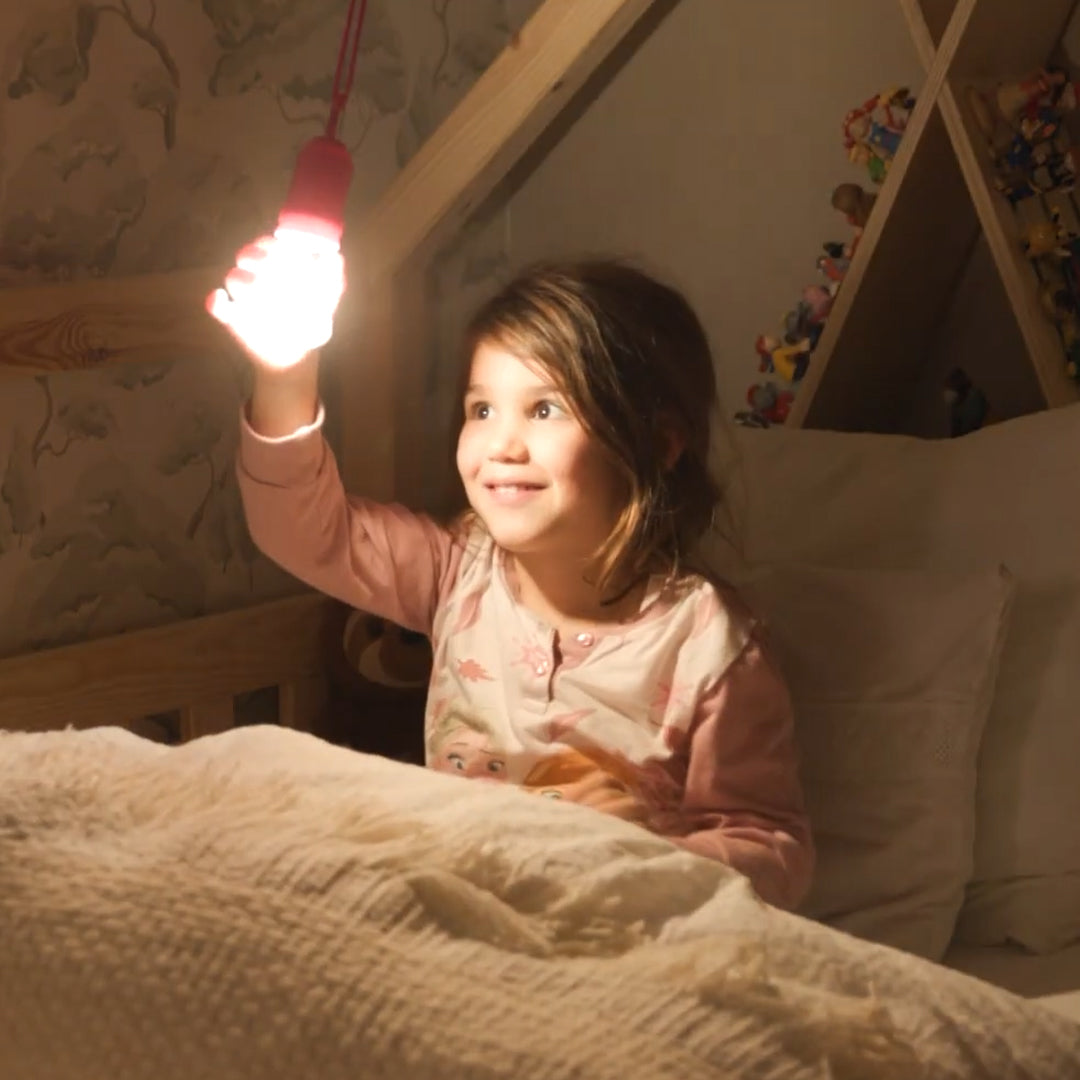 Kind hält kühlbleibende LED-Leuchte im Bett