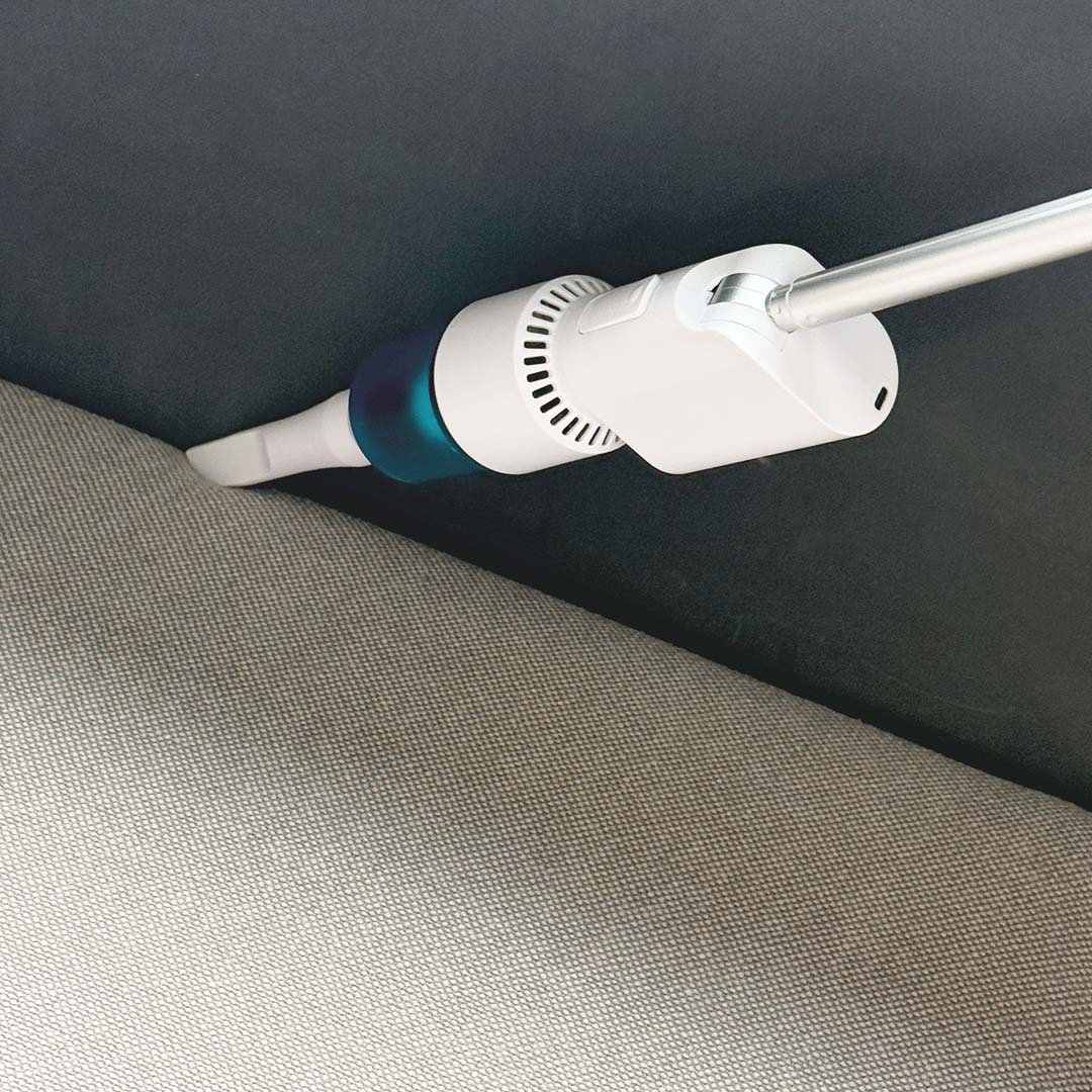 Akku-Staubsauger reinigt Sofa in schmalem Zwischenraum