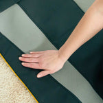 Eine Hand testet die Oberfläche der Belena AirStretch Matte mit strukturiertem und glattem Material.