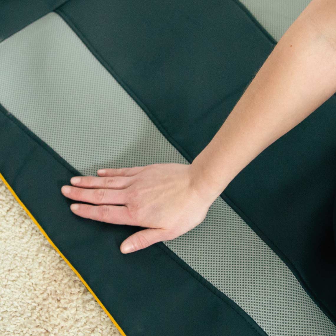 Eine Hand testet die Oberfläche der Belena AirStretch Matte mit strukturiertem und glattem Material.