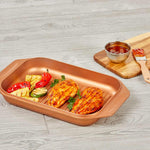 Livington Copperline WonderCooker – Grillpfanne mit Hähnchenfilets und Gemüse, serviert auf Holzoptikboden.