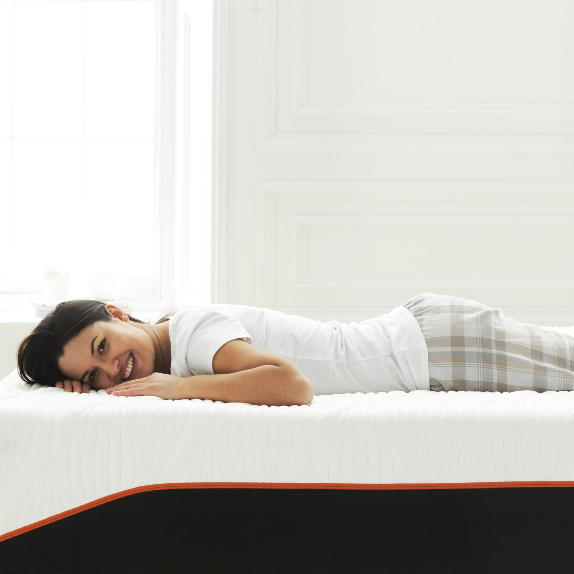 Frau liegt entspannt auf der OCTAsleep Smart Matratze – ideale Unterstützung für Bauchschläfer.