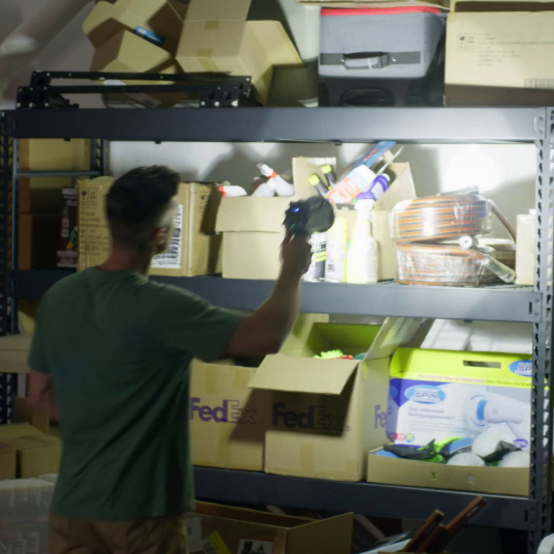 Mann nutzt LED-Arbeitsleuchte zur Beleuchtung eines Regals