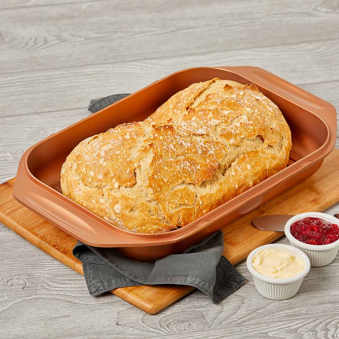 Livington Copperline WonderCooker – frisch gebackenes Brot in kupferfarbener Form, serviert mit Butter und Marmelade.