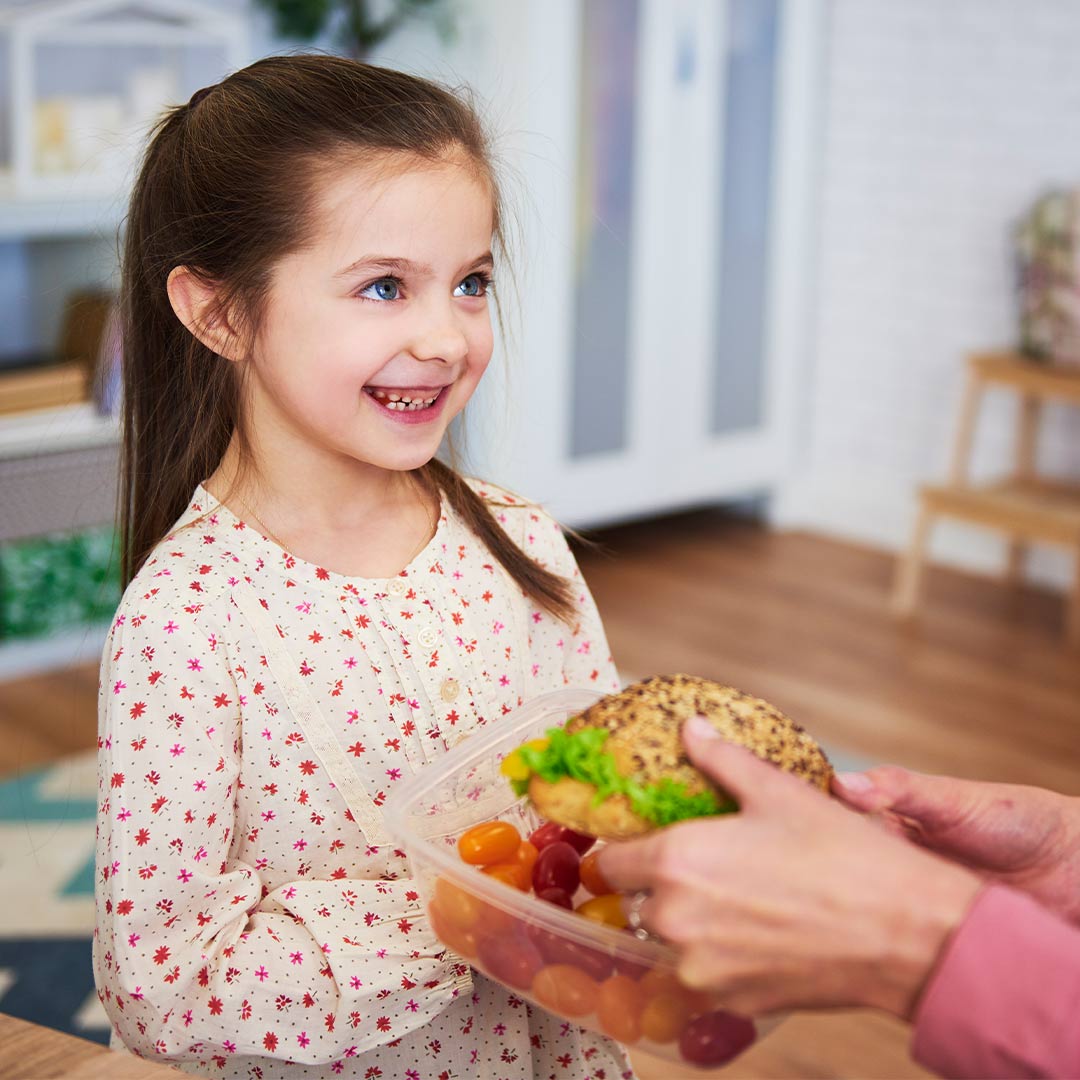 Kind bekommt frisches Essen aus einer Livington Flex & Fresh Frischhaltedose gereicht.