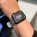 Smartwatch mit grauem Armband wird am Handgelenk getragen, Display zeigt digitale Uhrzeit an.