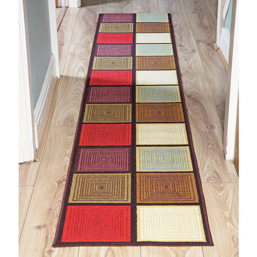 Langer Patchwork-Teppichläufer mit buntem Quadratdesign liegt auf einem Holzfußboden im Flur.