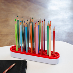 Bunte Buntstifte stehen ordentlich in einem rot-weißen Halter auf einem Tisch.