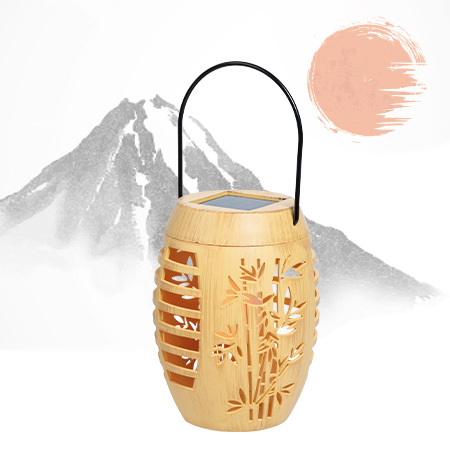 Solarleuchte in Bambusoptik mit ausgestanztem Bambusmotiv und schwarzem Henkel, vor stilisiertem asiatischem Hintergrund mit Berg und Sonnen-Illustration
