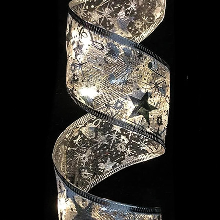 Nahaufnahme eines beleuchteten, transparenten Bandes mit silbernen Stern- und Schneeflockenmuster.