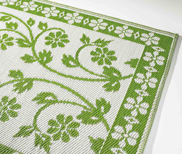 Grüner Outdoor-Wendeteppich mit floralem Muster und dekorativem Blütenrahmen.