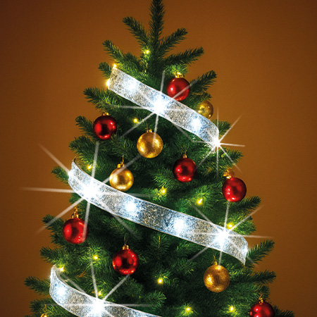 Weihnachtsbaum mit roten und goldenen Kugeln, leuchtendem Band und Lichterkette geschmückt.