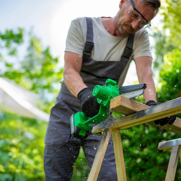 Mann sägt mit PocketSaw Pro ein Holzbrett im Garten